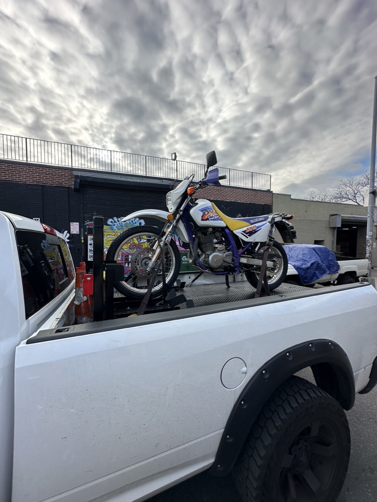 White and yellow dirt bike secured on the pickup