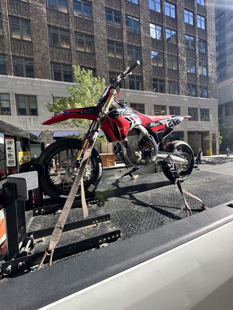 Red dirt bike strapped to the transport deck