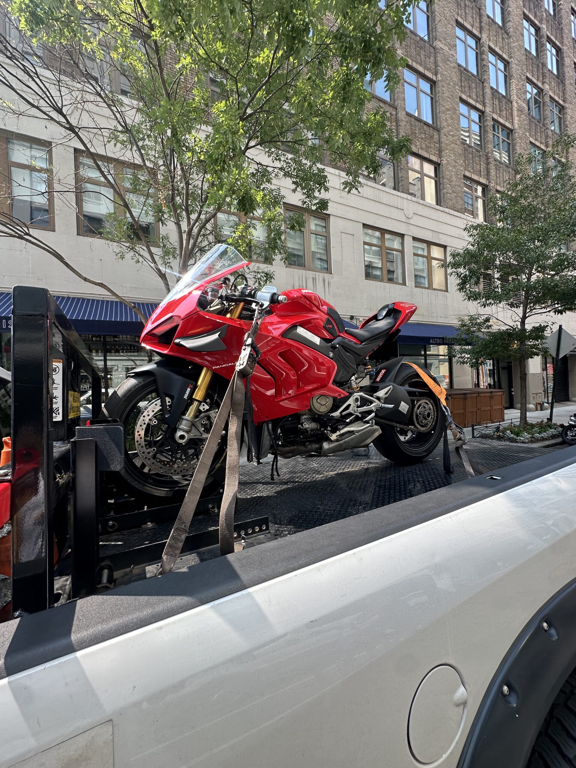 Red sport motorcycle secured for transport on a city street