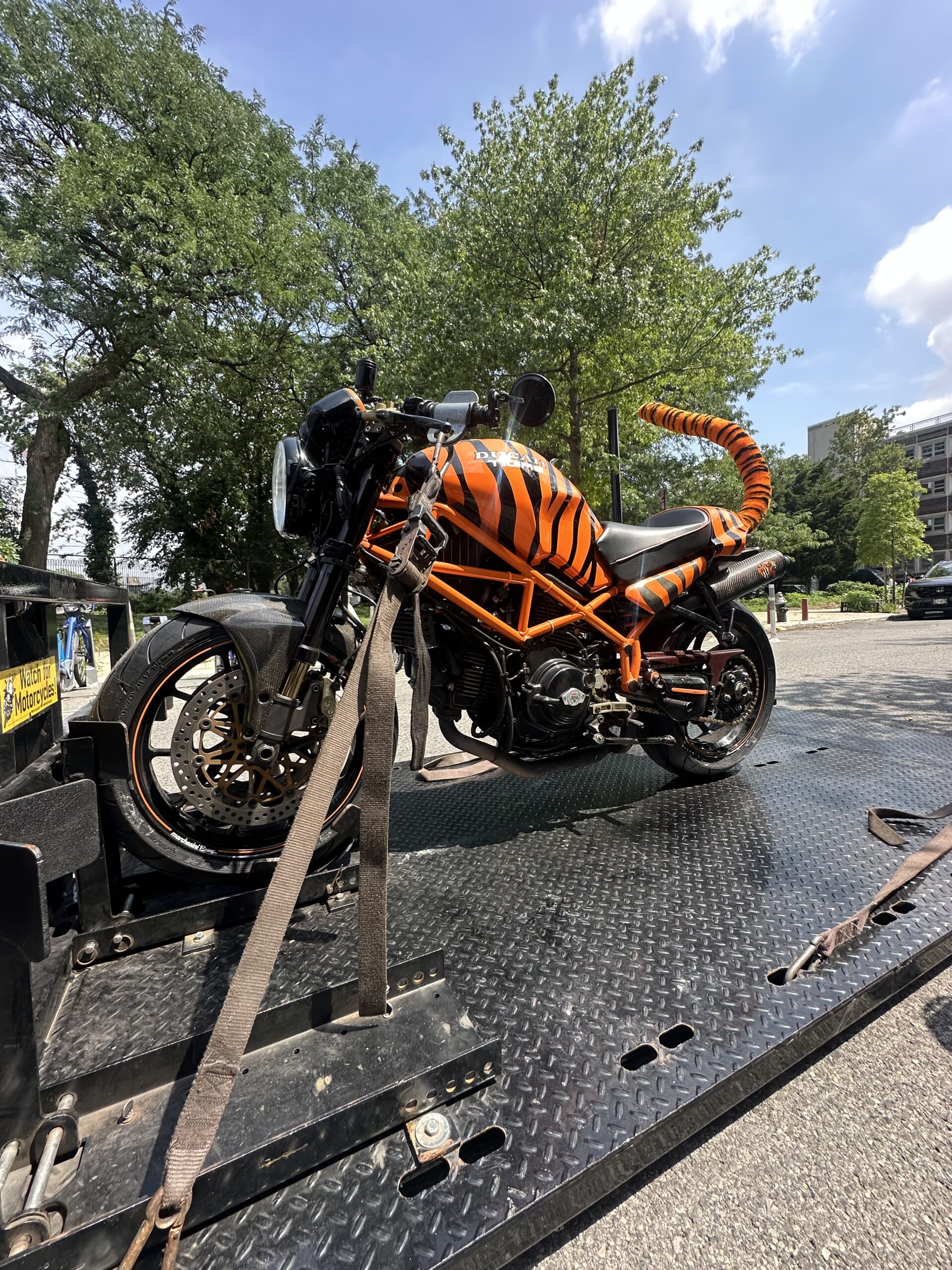 Orange frame motorcycle strapped to the transport deck