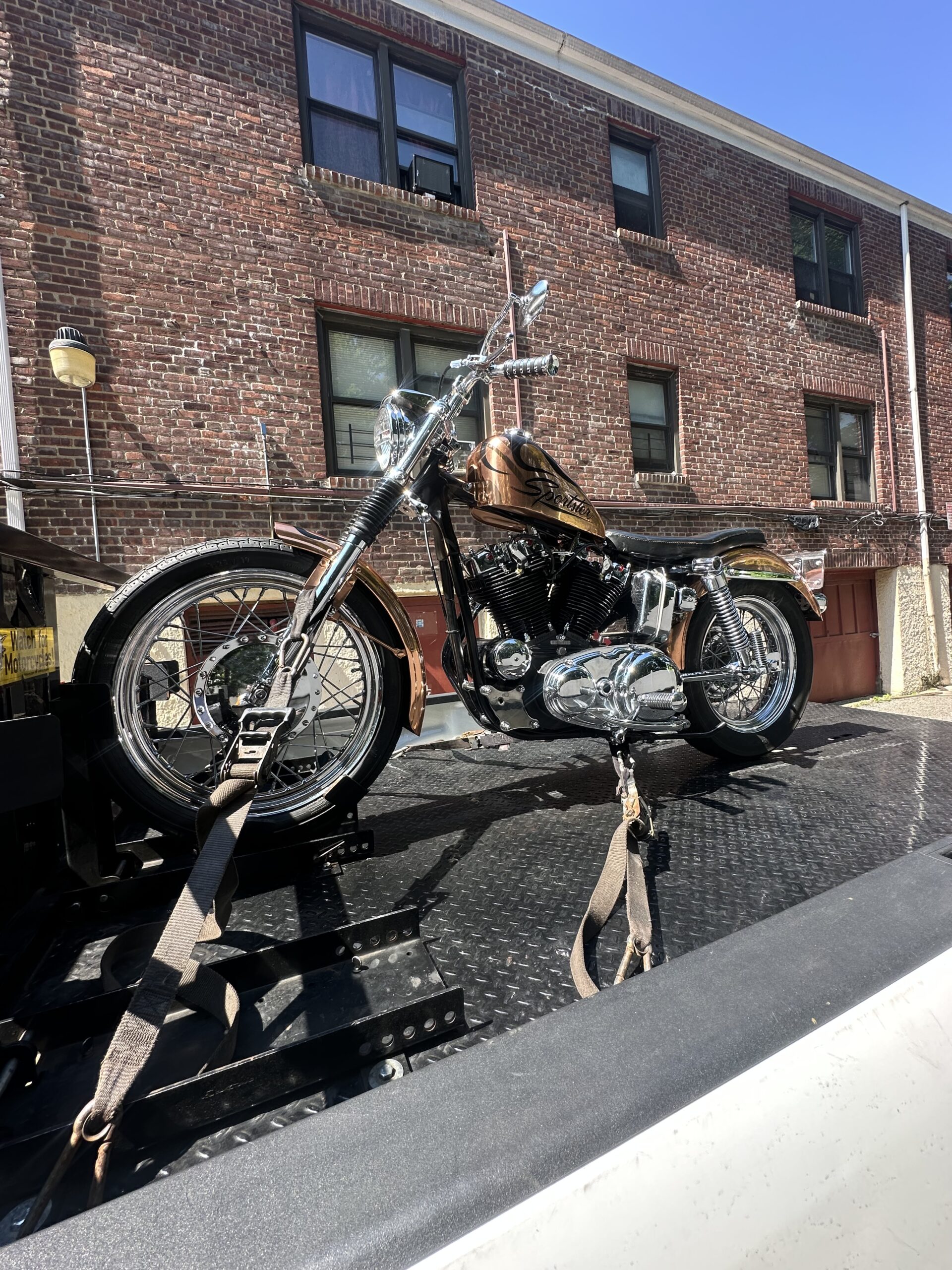 Classic black motorcycle strapped to the transport deck