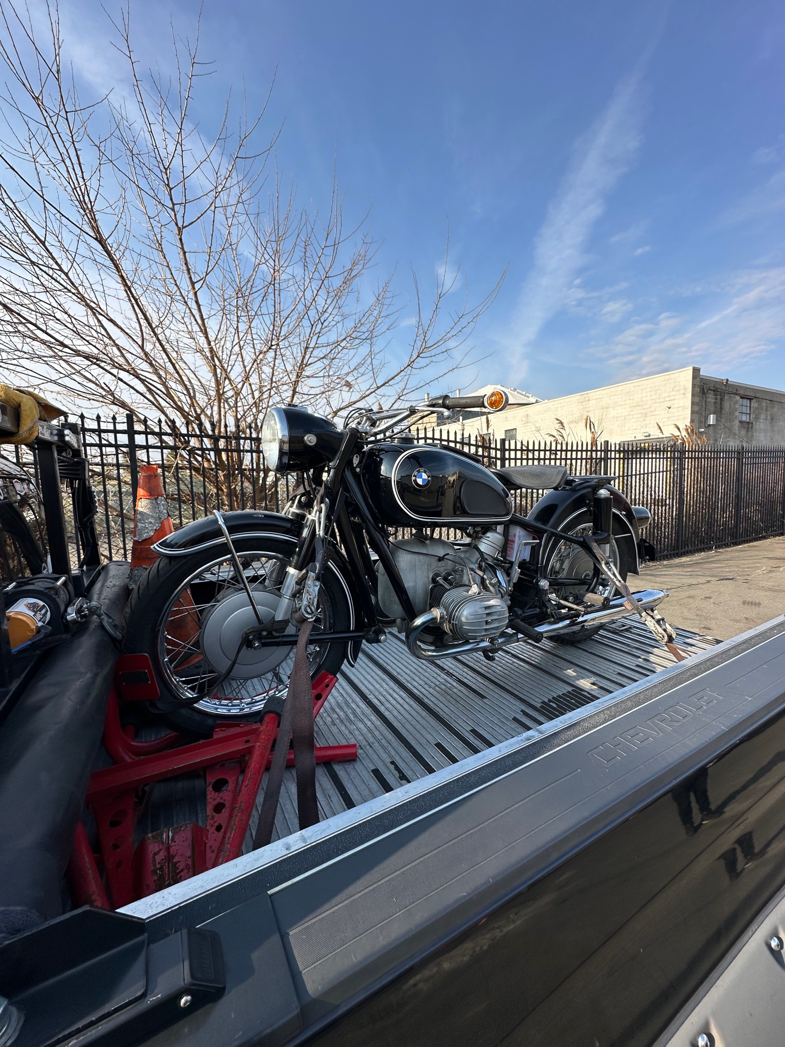 Classic motorcycle secured for delivery under a blue sky
