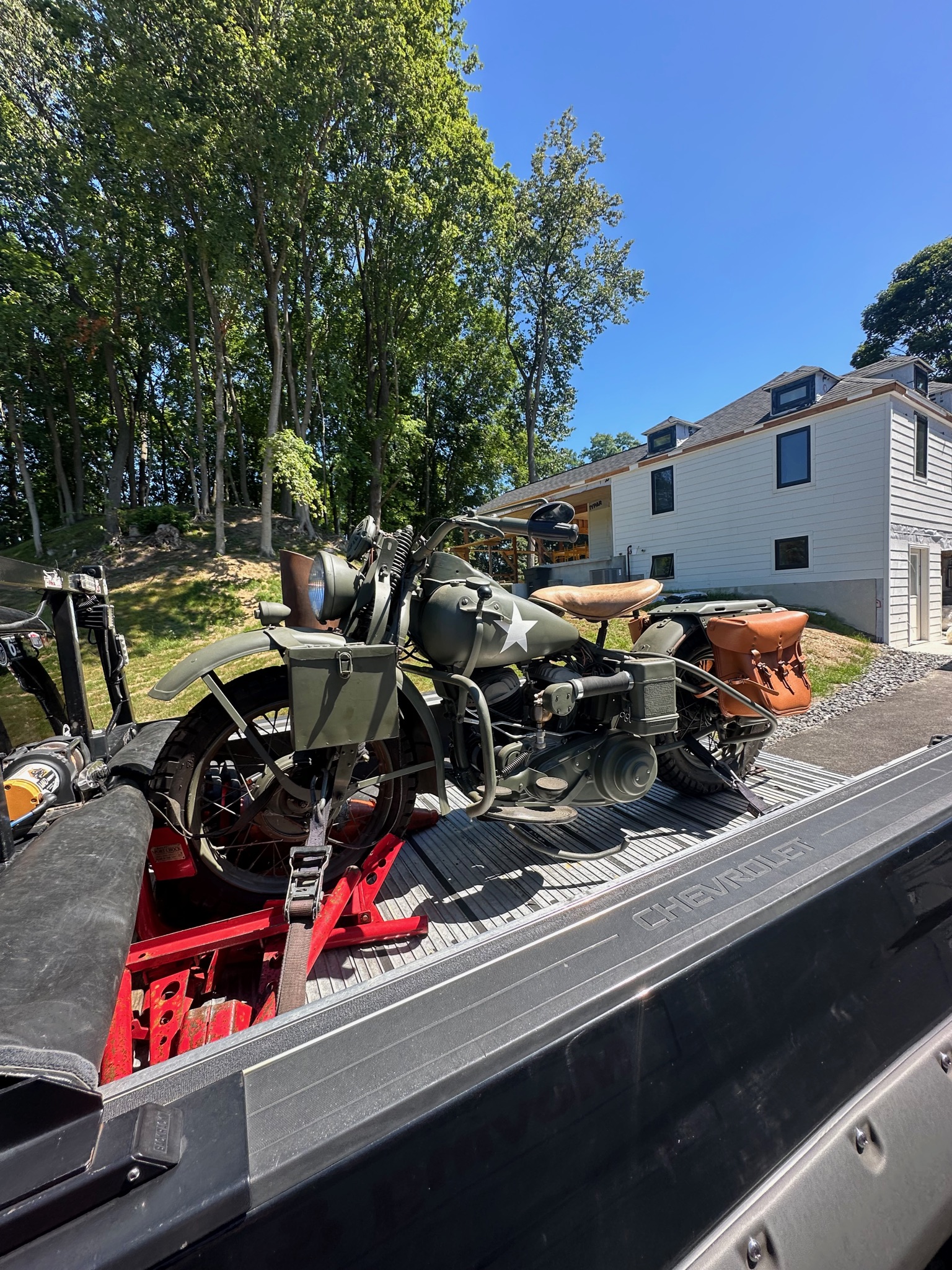 Motorcycle loaded on the transport deck on a tree-lined street