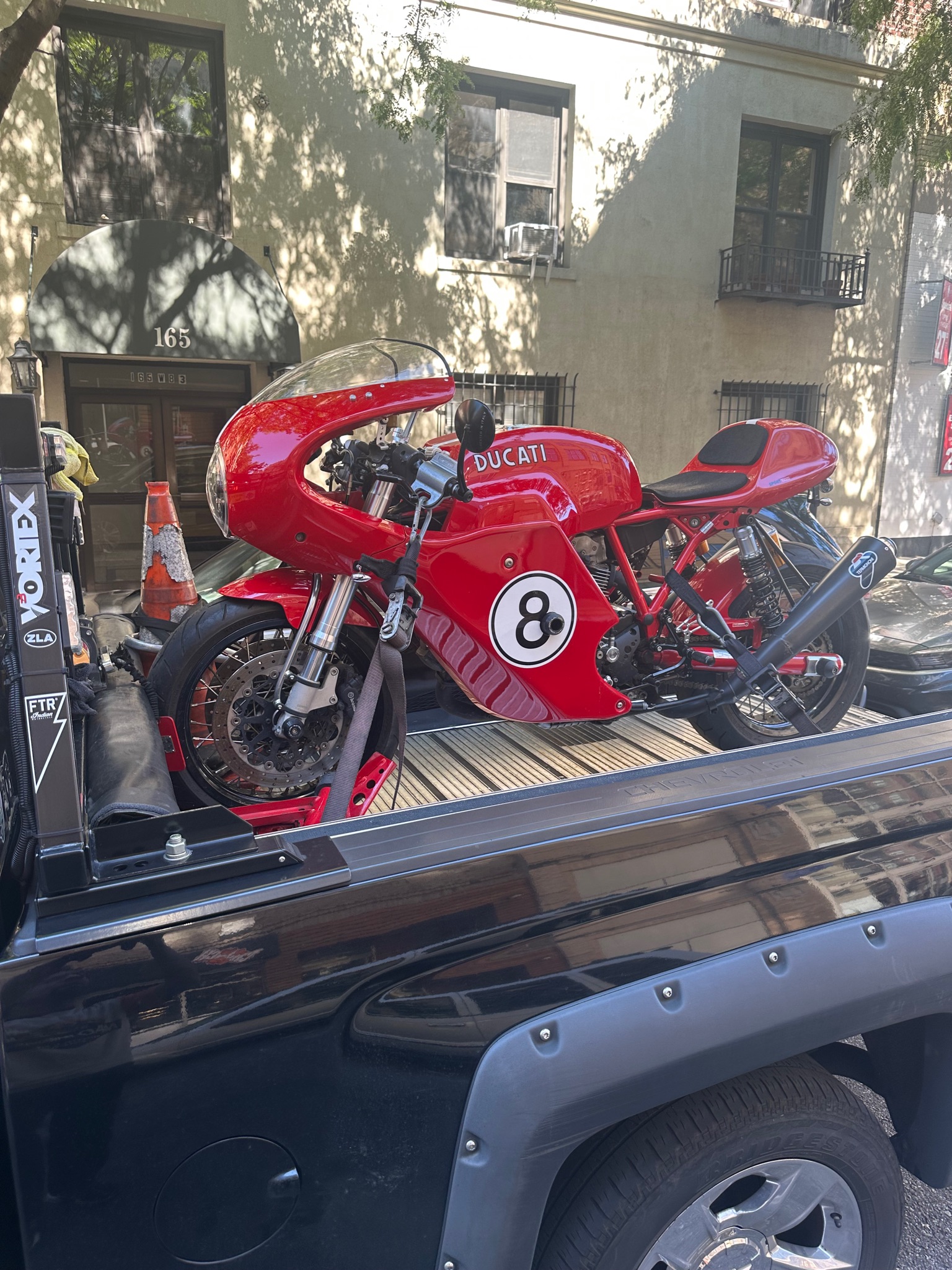 Red number eight race motorcycle secured on the transport deck