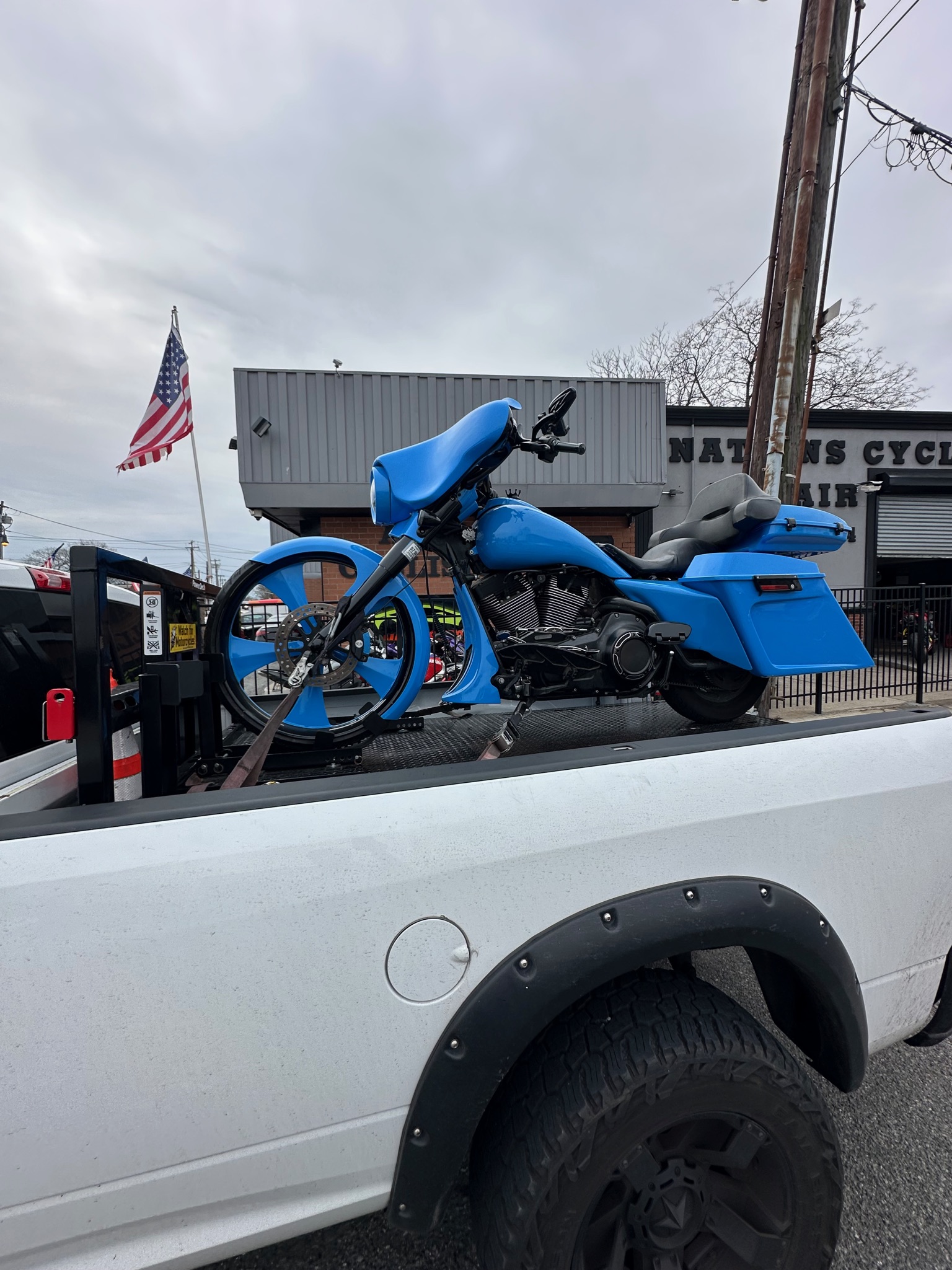Blue motorcycle carried on the white MAD Transpo NYC pickup