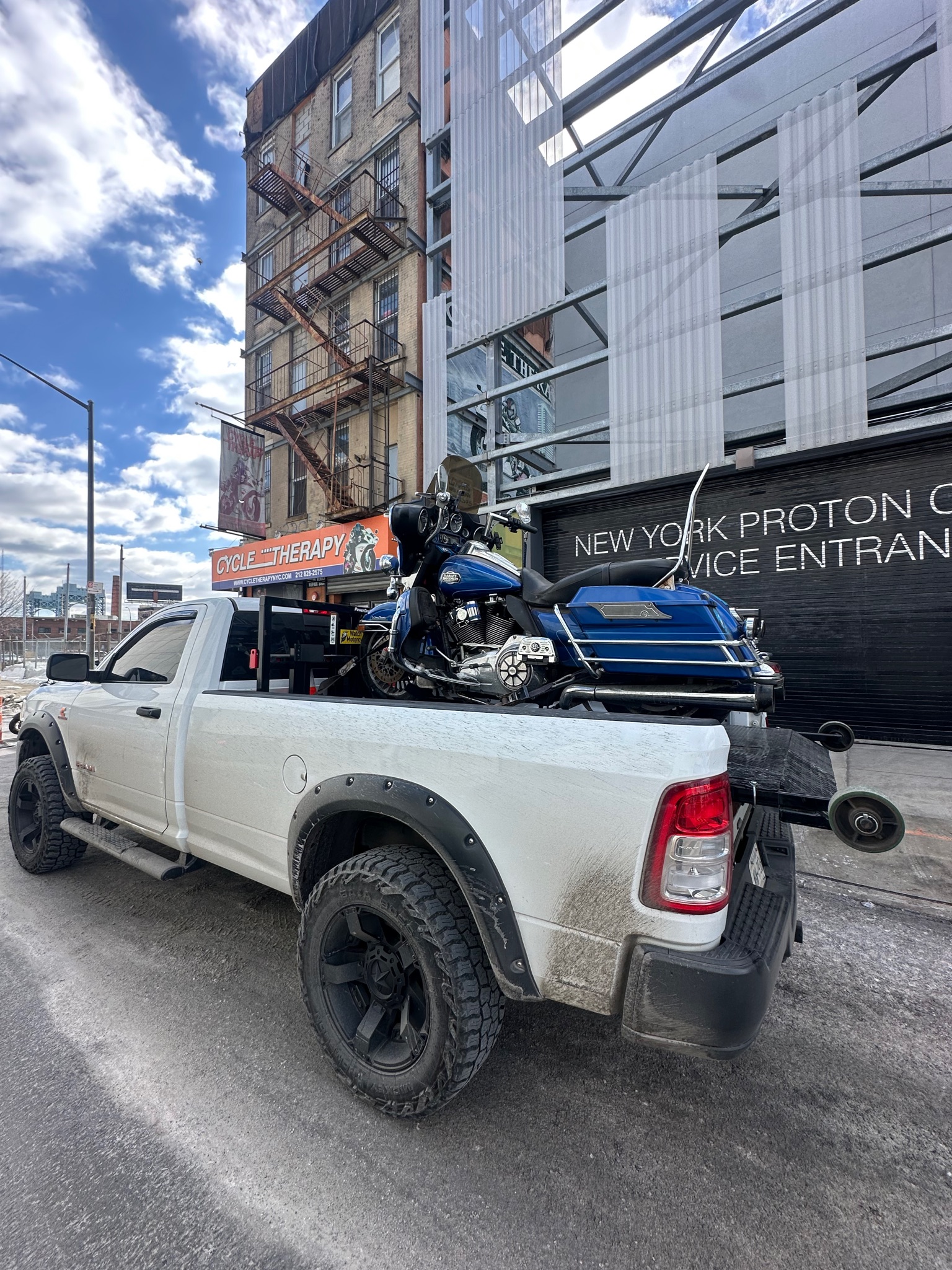 MAD Transpo NYC pickup with a blue motorcycle secured for delivery