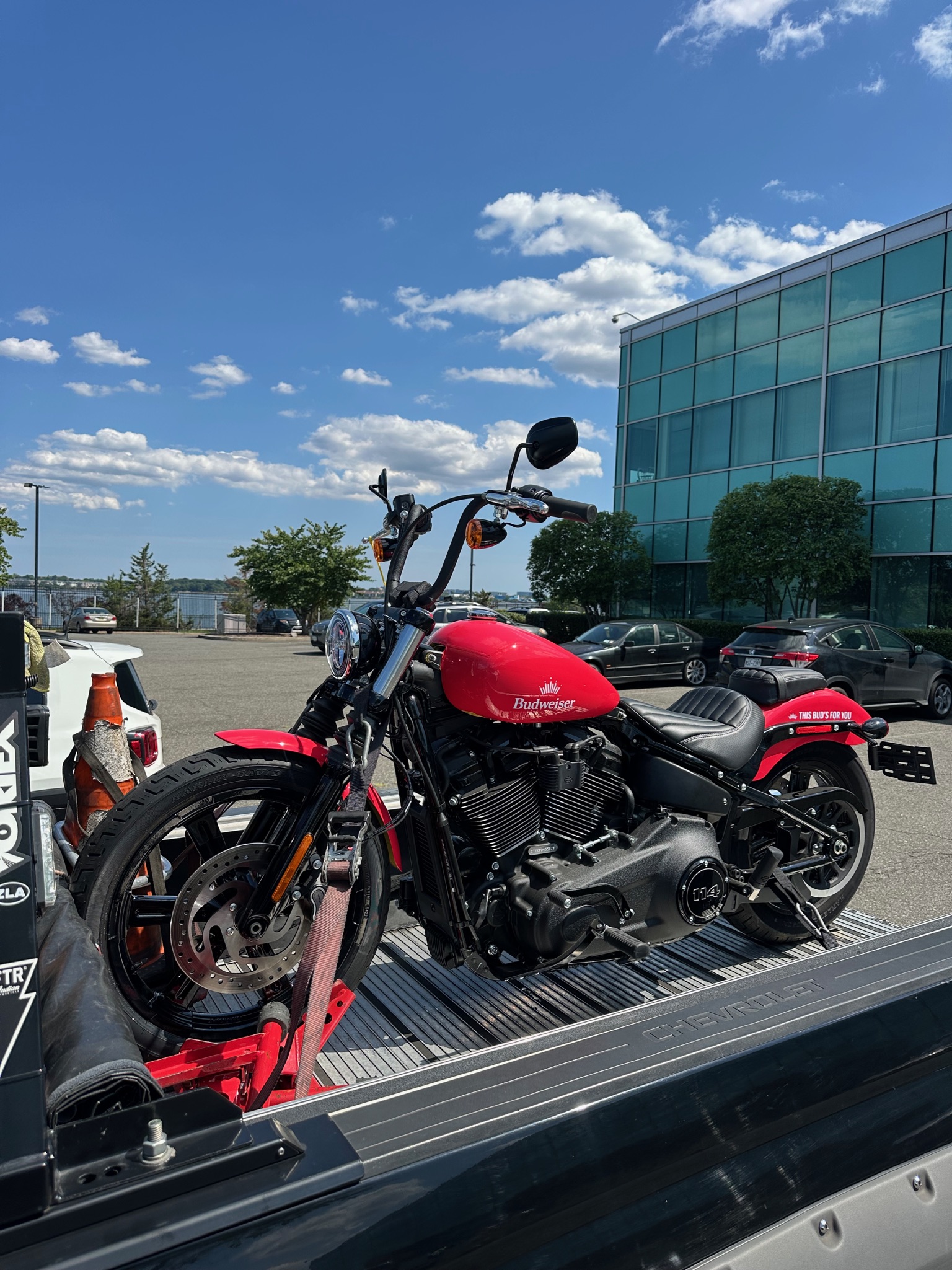 Red motorcycle secured for transport under a blue sky
