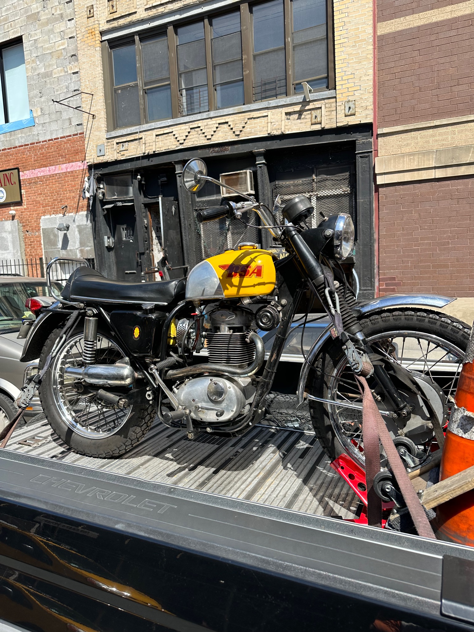 Yellow and black classic motorcycle secured for transport
