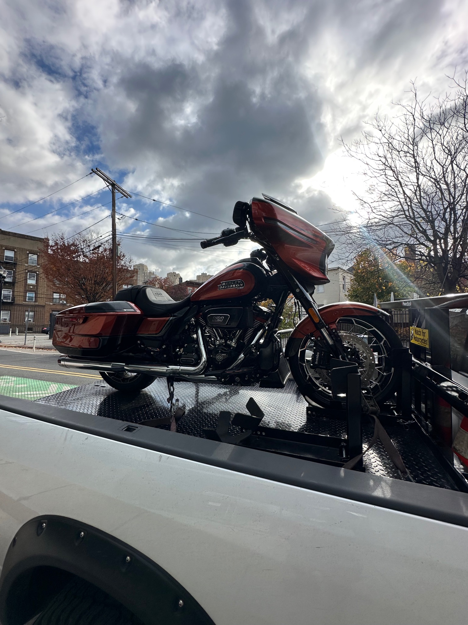 Burgundy touring motorcycle loaded on the white pickup