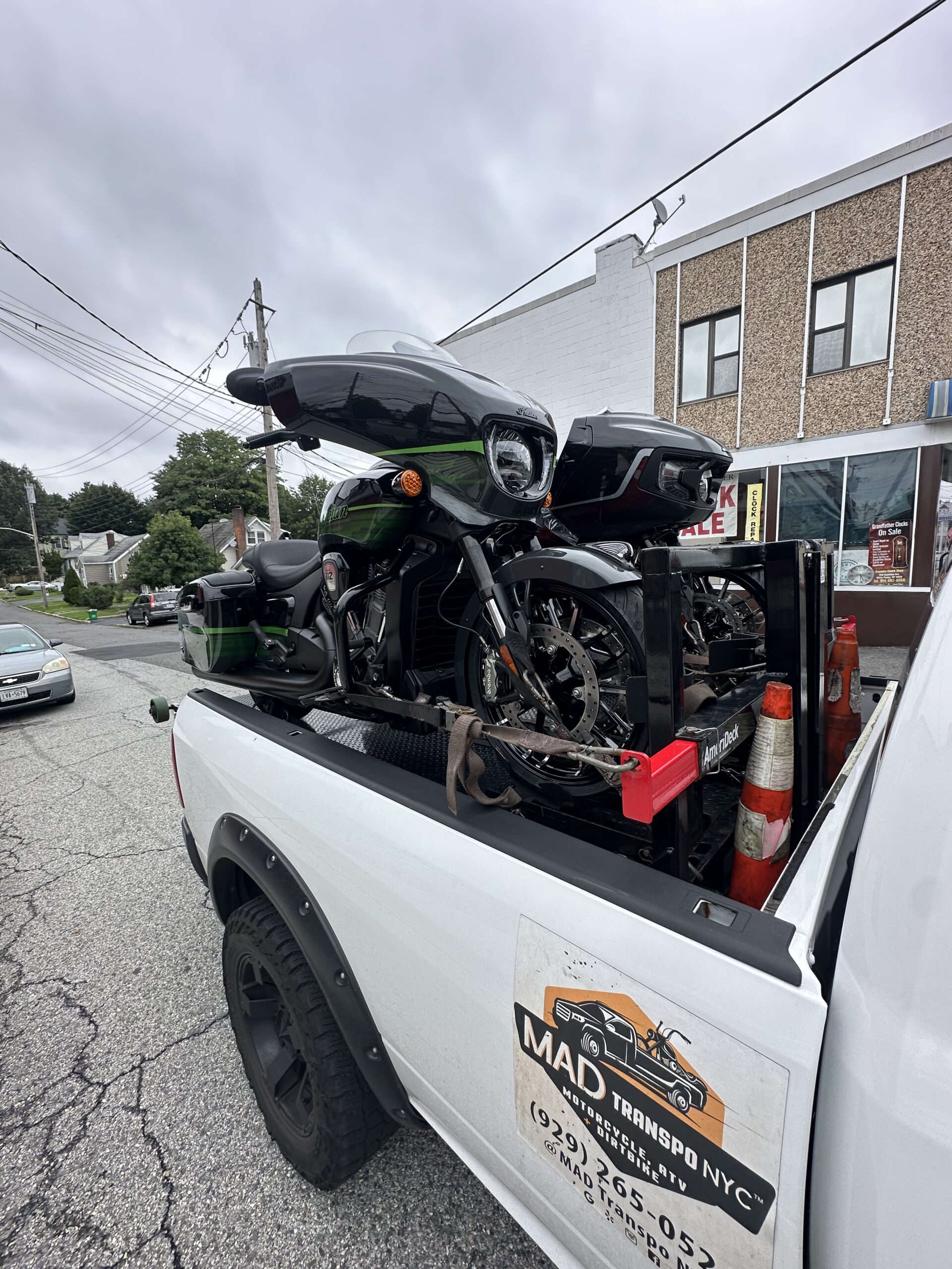 Black touring motorcycle carried on the white pickup
