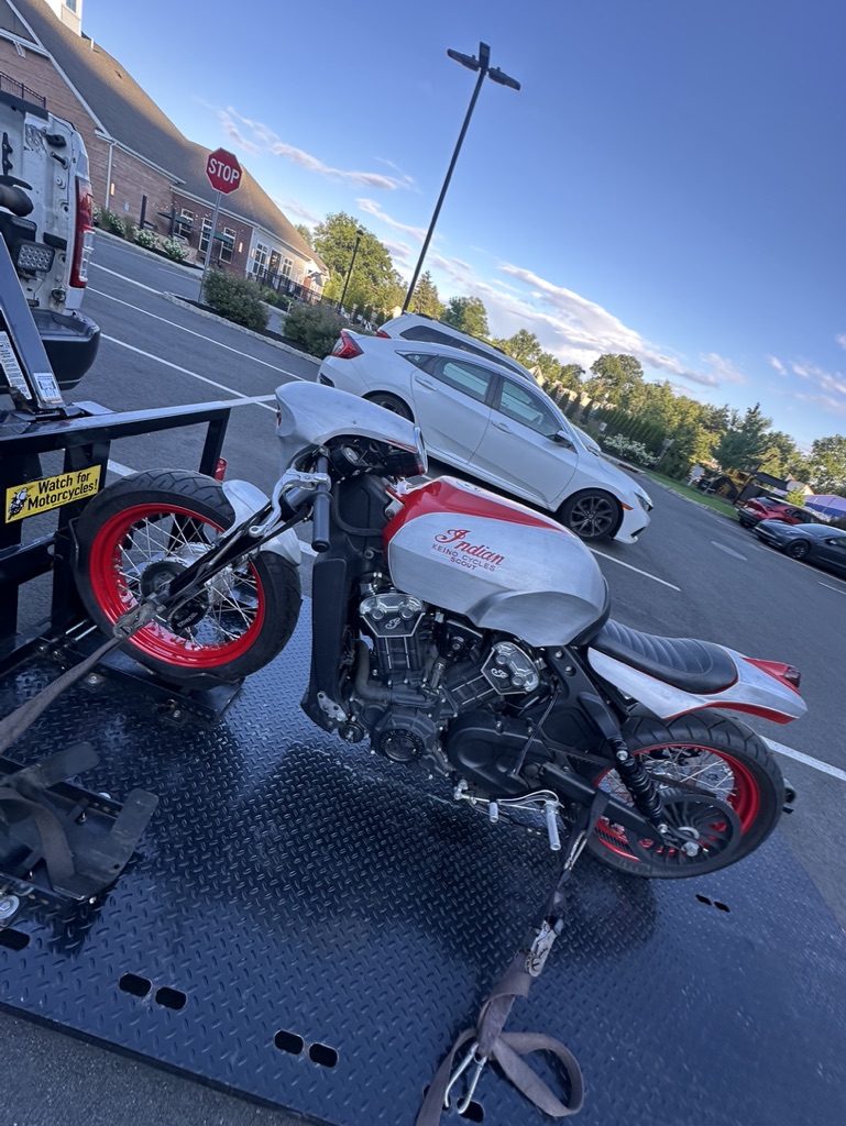 White and red motorcycle secured for roadside transport