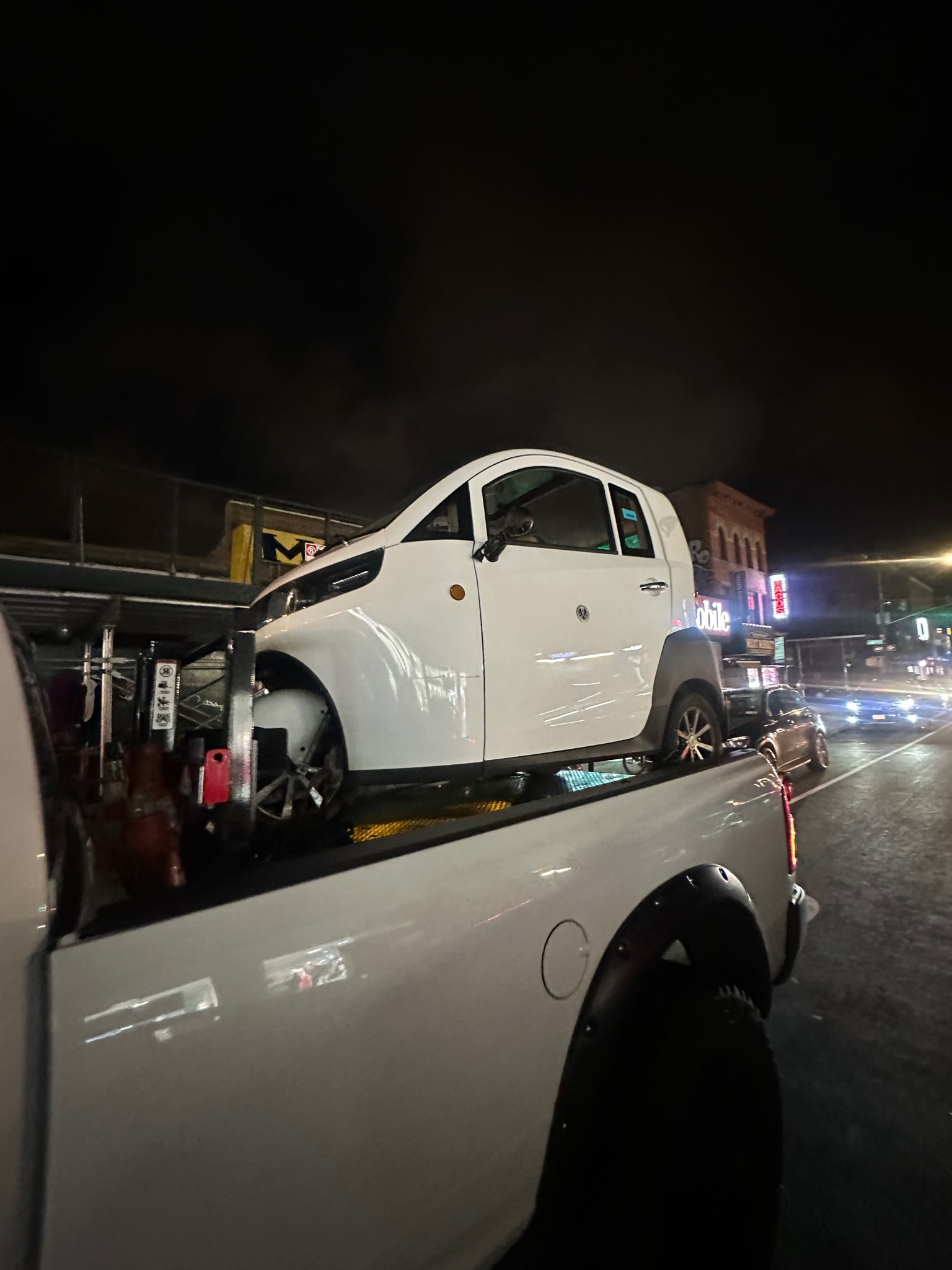 Small white three-wheel vehicle transported at night